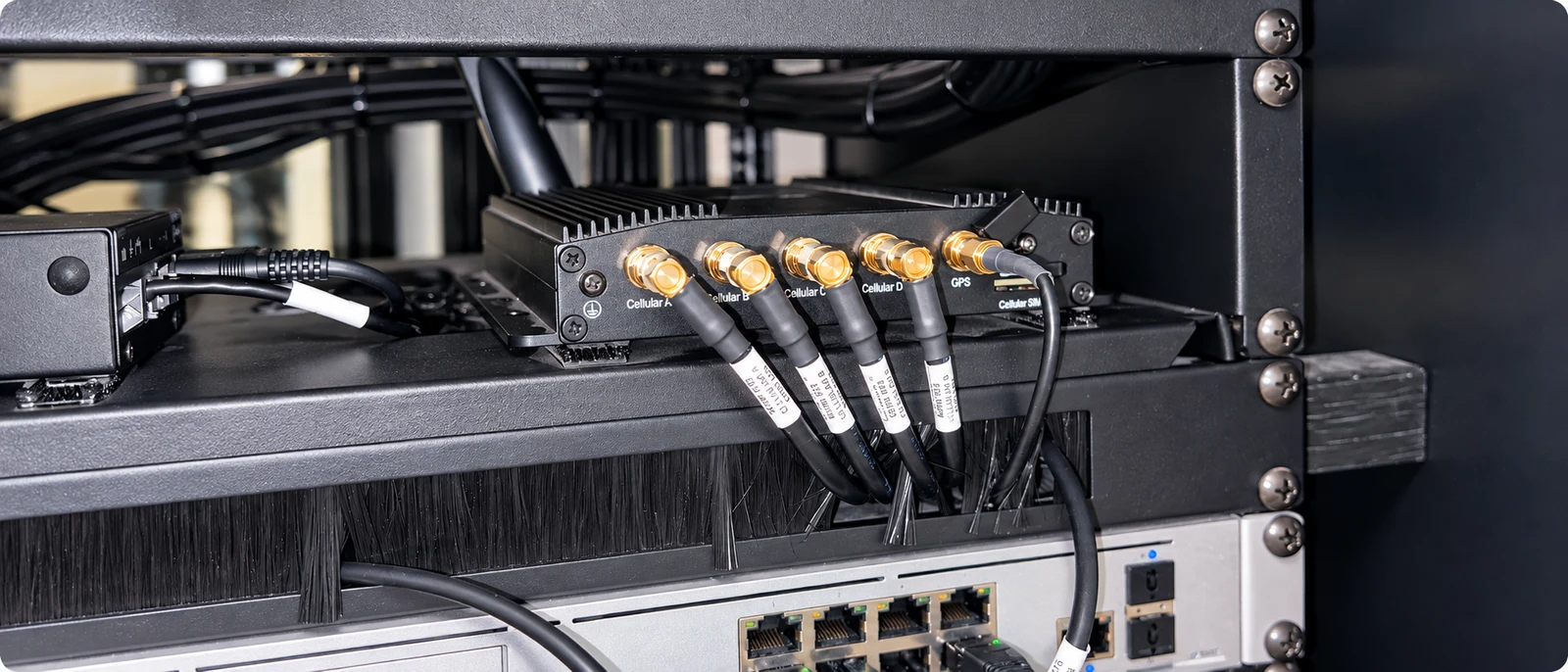 Equipos de comunicaciones y conexiones de antena en un armario técnico a bordo.