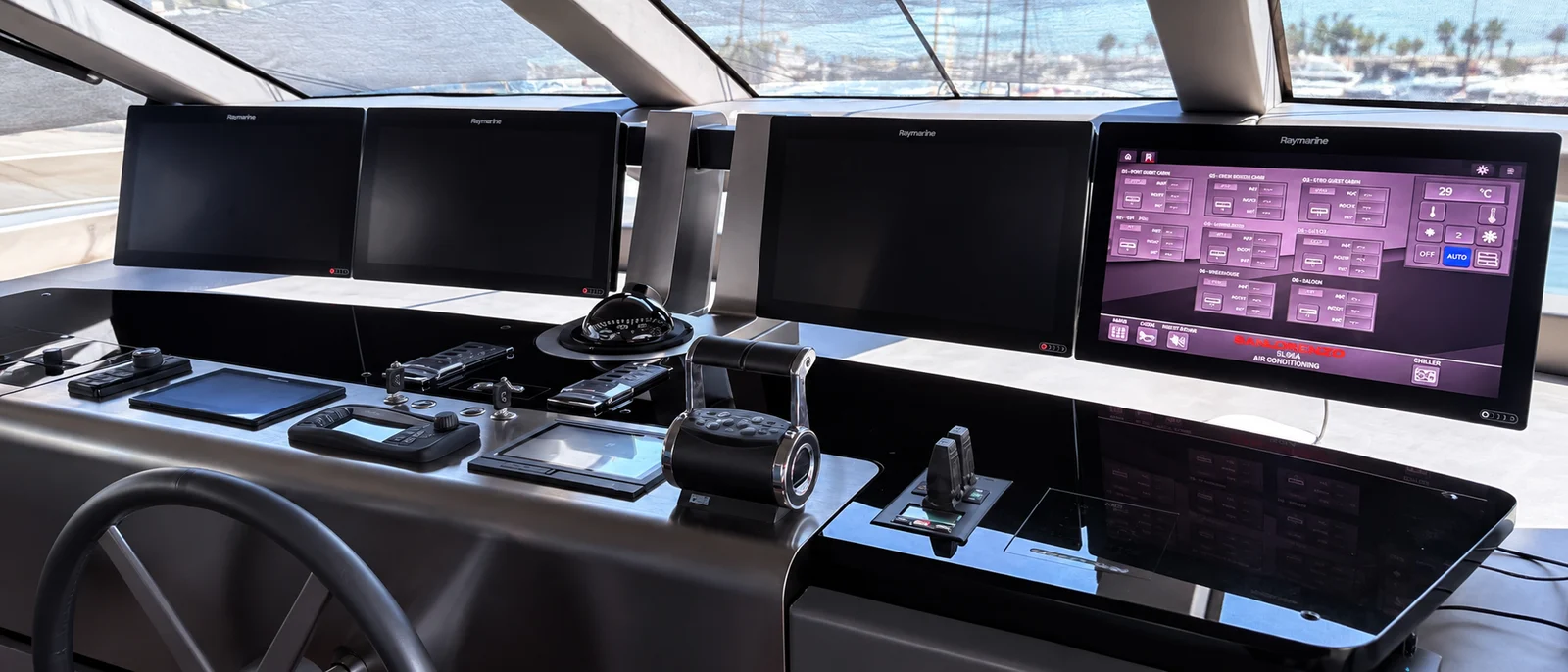 Yacht bridge with Raymarine displays and helm controls.